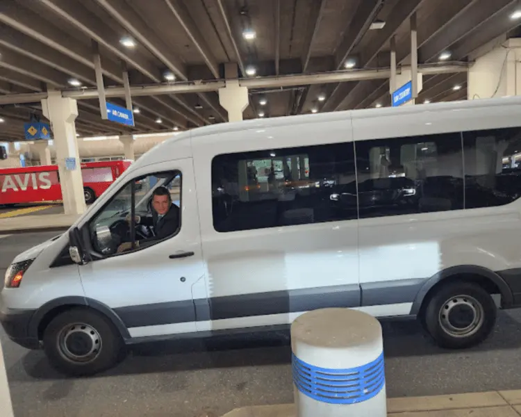 Ford Transit passenger van at an airport terminal curb
